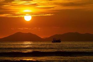 Boating in the sea with waves and sky, golden sun photo