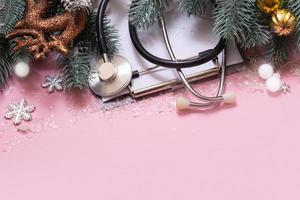 Doctor's stethoscope and XMAS decorations top view. Medical winter holidays Christmas New Year background with copy space photo