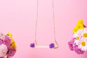 A swing with chrysanthemum flowers as a stand for your cosmetic product photo