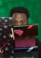 man hidden behind many gift boxes for christmas carrying surprises photo