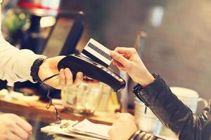 mujer pagando en restaurante foto