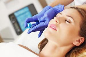 Woman having facial treatment in beauty salon photo