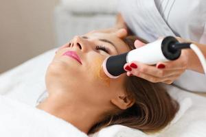 Woman having facial peeling in beauty salon photo