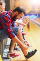 amigos poniéndose zapatos de bolos foto