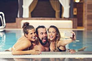 Group of friends relaxing in pool spa photo