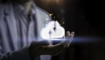 Businessman holding a cloud business analytics and Data management system on computer, online document management and metrics connected to database. Corporate strategy for finance, operations, sale photo