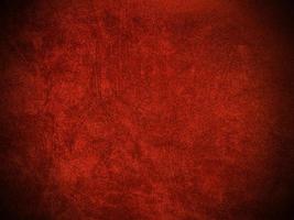 textura de tela de terciopelo rojo oscuro utilizada como fondo. fondo de tela rojo oscuro vacío de material textil suave y liso. hay espacio para el texto.. foto