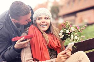Man giving surprise gift to woman in the park photo