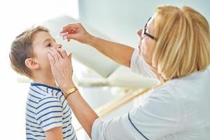 Pediatrician doctor examining little kids in clinic photo