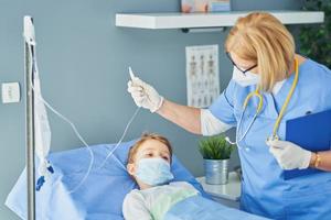 Adult woman and young patient in hospital bed photo