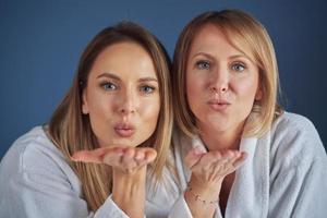 Two girls wearing bathrobe in spa or hotel having fun photo