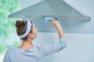 Young woman cleaning dirt in the kitchen photo