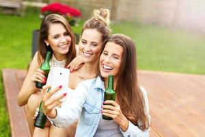 feliz grupo de amigos bebiendo cerveza al aire libre foto