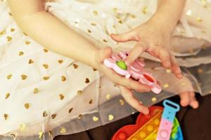 Pop it is a multi-colored anti-stress toy in children's hands. Bubble game. Antistress toys. photo