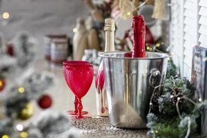 botellas de champán y copas en la mesa con el telón de fondo de las decoraciones navideñas foto