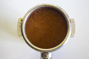 porta filter with ground coffee and coffee bean isolated from a white background photo