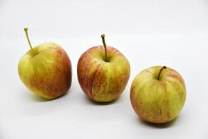 tres manzanas rojas y amarillas sobre un fondo blanco. primer plano de manzanas. deliciosas manzanas sobre un fondo blanco. foto