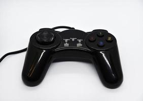 The gamepad is black and shiny on a white background. Game joystick close-up. A gamepad for a game console. photo