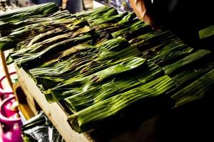 otak - otak is a food made from minced mackerel fish meat wrapped in banana leaves, baked, and served with spicy and sour sauce. otak-otak is traditional fish cake from indonesia photo