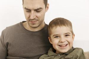 Portrait of father and son. Dad loves his boy. Positive family relationship. Young attractive man and his little kid spending time together. Respect and support, be a good example. Father's Day. photo