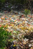 basura plástica derramada en la tierra de la gran ciudad. botellas de plástico sucias usadas vacías. contaminación plástica. contaminación ambiental. problema ecológico. foto