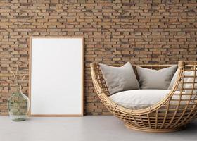 Empty vertical picture frame on brick wall in modern living room. Mock up interior in scandinavian, boho style. Free space for picture. Rattan sofa and dried grass in glass vase. 3D rendering. photo