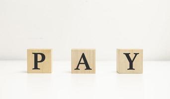 word pay on wooden blocks on white background photo