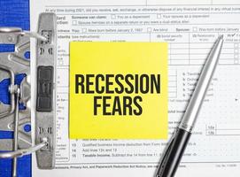 Recession fears words on paper notebook with pen photo