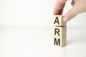 Adjustable Rate Mortgage ARM abbreviation on wooden blocks and hand photo