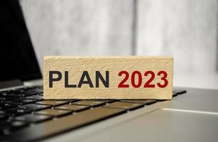 Bloque de 2023 años contra el fondo de la computadora portátil. objetivo, objetivo, resolución, estrategia, plan, finanzas, presupuesto, motivación y comienzo de año nuevo foto