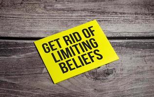 Get Rid Of Limiting Beliefs Text on business paper on office table photo