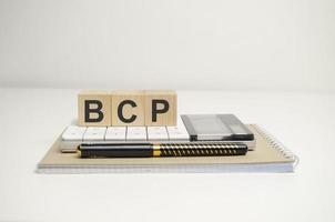 bcp, planificación de la continuidad del negocio, palabra sobre bloques de madera y material de oficina foto