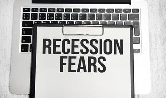 Recession fears words on paper tablet on laptop photo