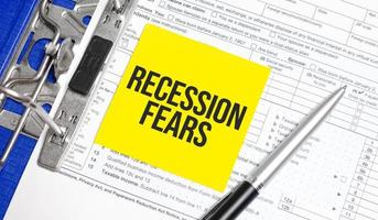 Recession fears words on paper notebook with pen photo