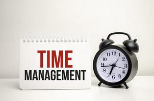 time management words with calculator and clock with notebook photo