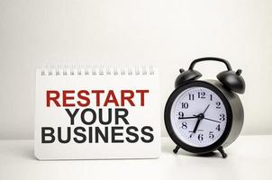 restart your business words with calculator and clock with notebook photo