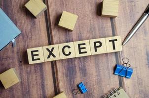 Except word written on wooden blocks on a dark table photo