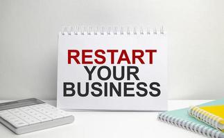 restart your business words on paper notebook with office supplies photo