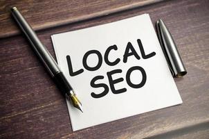 un bloc de notas con texto de SEO local. concepto de negocios y finanzas. lugar de trabajo, plano con espacio de copia. foto