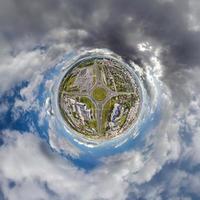 pequeño planeta en el cielo con nubes que dominan el casco antiguo, el desarrollo urbano, los edificios históricos y los cruces. transformación del panorama esférico 360 en vista aérea abstracta. foto