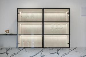 cupboard with lighting with wine glasses in luxure kitchen in studio apartments photo