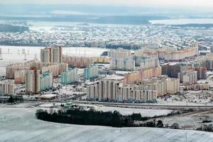 winter panoramic aerial view of a huge residential complex with high-rise buildings with snow photo