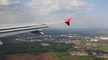 vista desde la ventana del avión en la ciudad de moscú. descenso de un avión de pasajeros al aeropuerto. llega el avión pov, día de verano. vista superior de la ciudad video