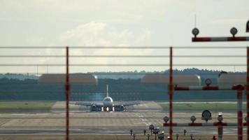 el avión de pasajeros llegó al aeropuerto temprano en la mañana. vista de la franja a través de la cerca video