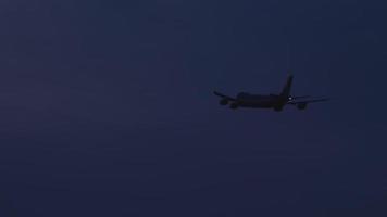 Widebody airfreighter on the final approach before landing on the background of dusk sky video