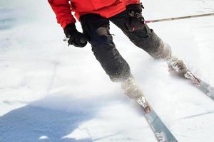 Close up male skier bottom view of ski boots and skis while stop on carving in fast motion photo