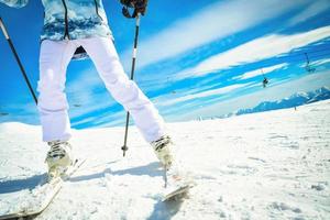 Close up woman skier bright bottom view of ski boots and skis while stop on carving in fast motion photo