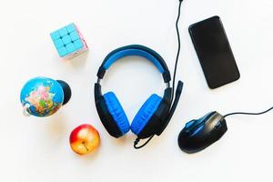 Top view student workspace concept, smartphone, mouse, keyboard, headset on white background with copy space. Kids development. Elementary remote study set up. Study from home photo