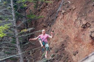 Slackliner balancing on the line getting ready to stand photo