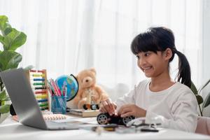 Asia students learn at home in coding robot cars and electronic board cables in STEM, STEAM, mathematics engineering science technology computer code in robotics for kids concept. photo